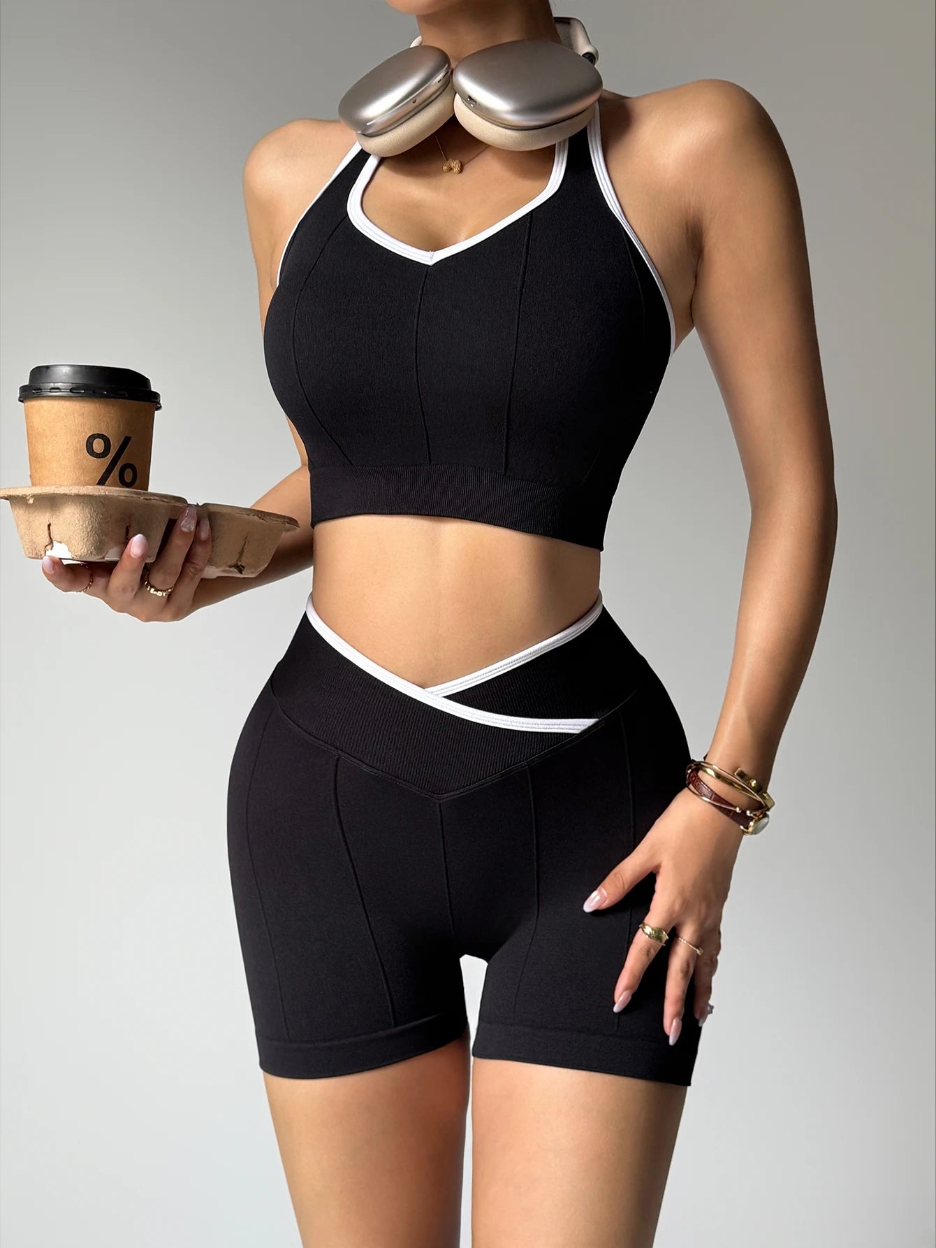Conjunto de treino feminino 2 peças — top halter elegante e calções de cintura alta respirável, em patchwork preto e branco para ioga e ginásio.